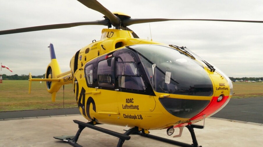 Ein gelber Hubschrauber steht auf einem Landeplatz.