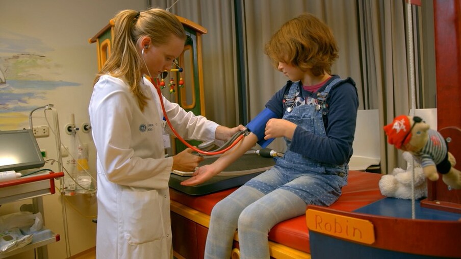 Ärztin misst Blutdruck bei Mädchen