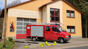 Ein Einsatzwagen der Feuerwehr steht vor einer Feuerwache.